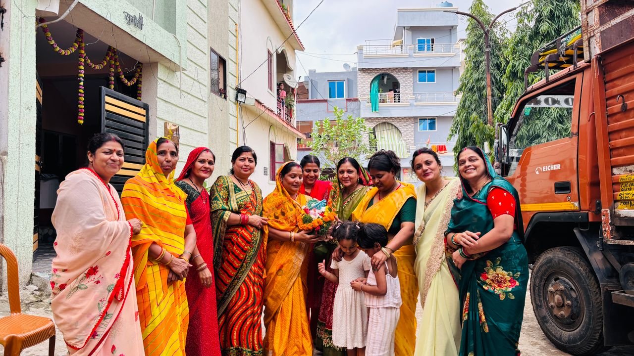 Group of women in colorful sarees celebrating outdoors in an Indian neighborhood with children. Cultural festivity vibe.